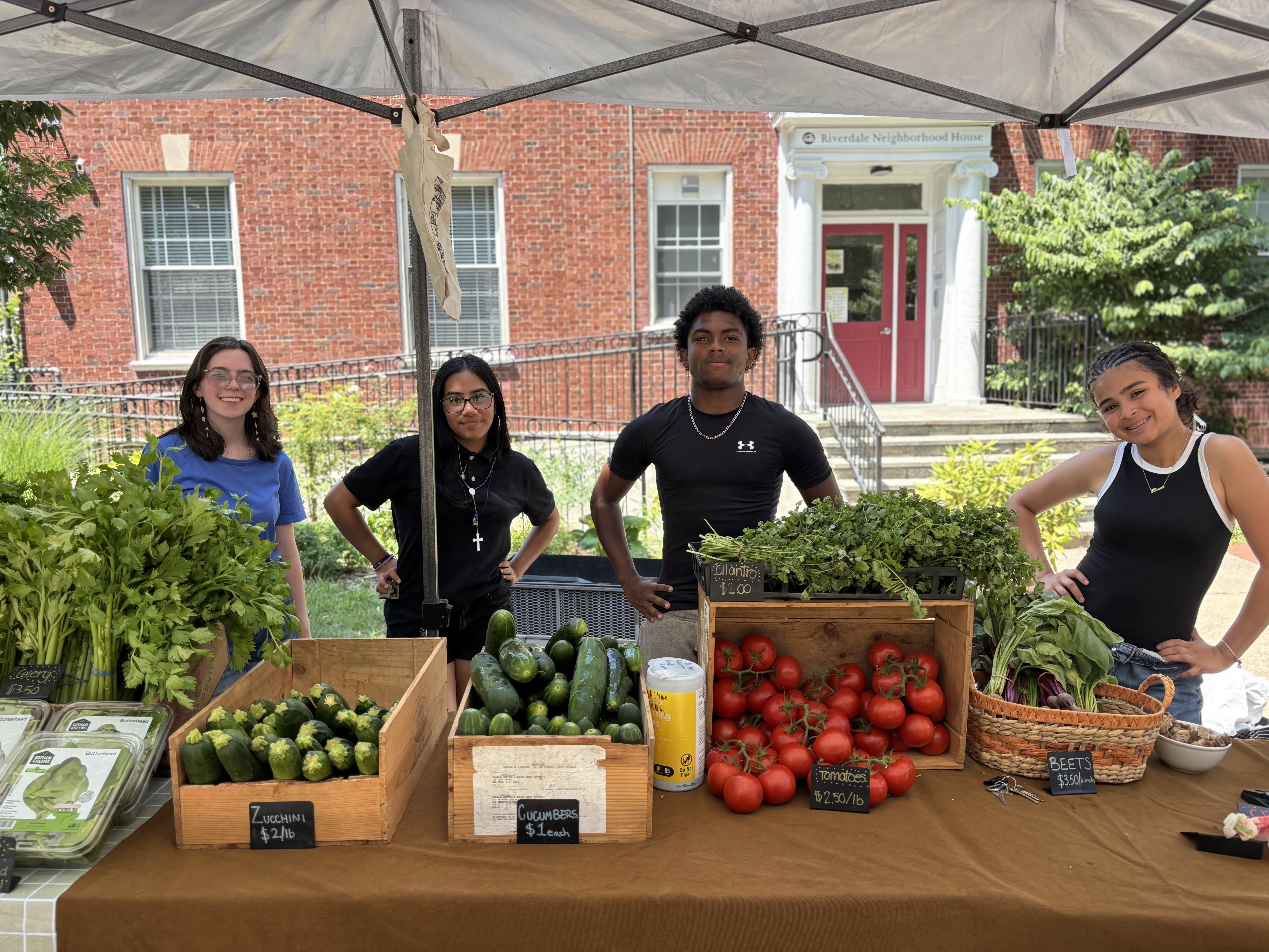Volunteers next to a stand supplying fresh vegetables