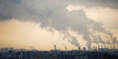 A far off view of a city with plumes of smoke rising into the air