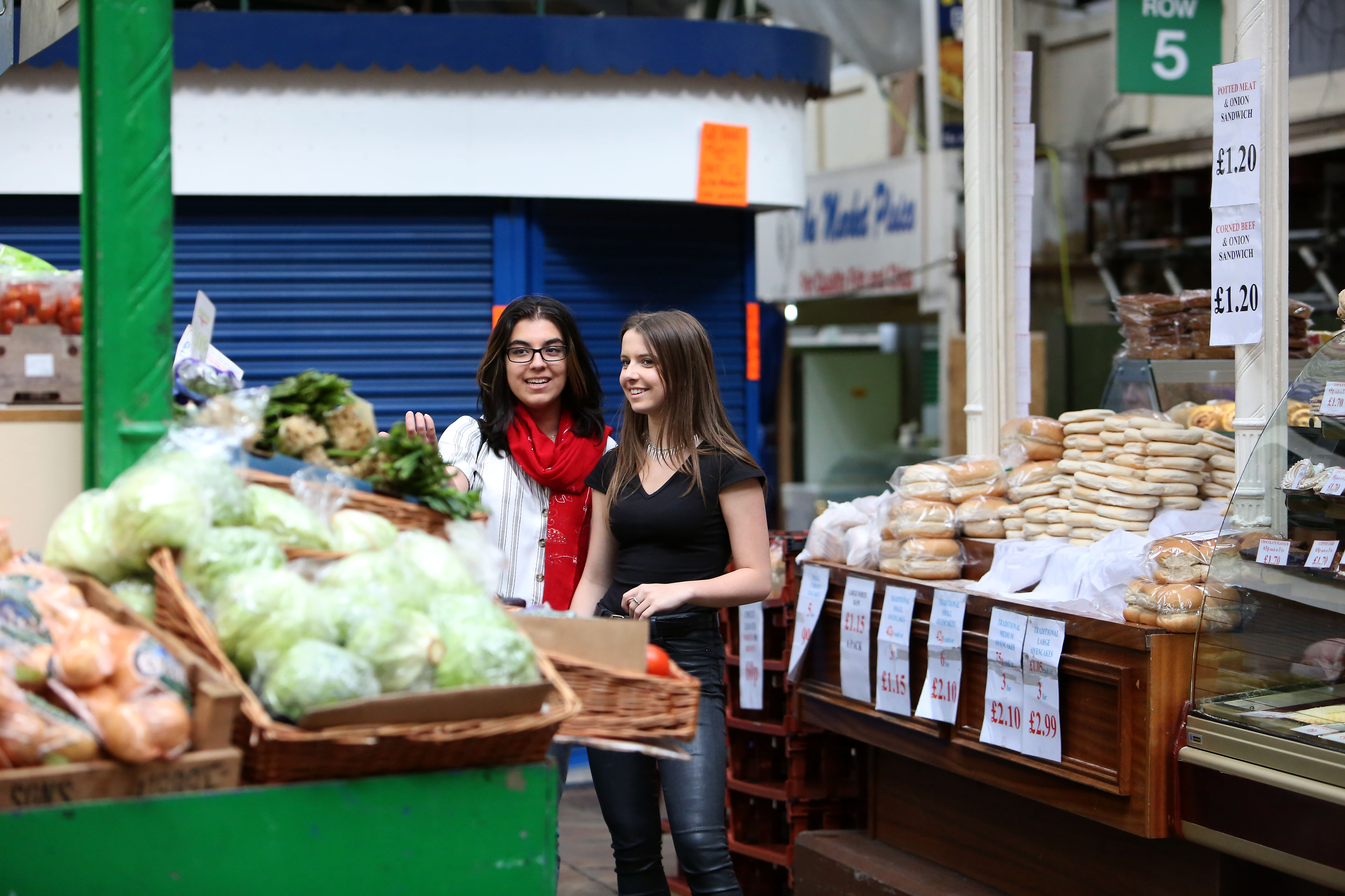 Two people at a produce stall in Leeds Kirkgate Markets.