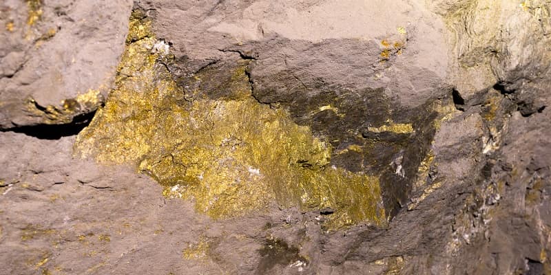 Gold mineral vein in rock face