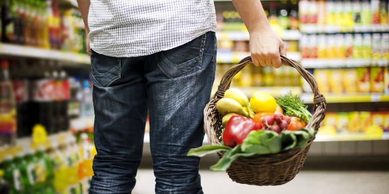 Man in supermarket with basket of vegetables