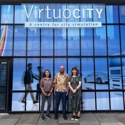 3 people stood in a line outside Virtuosity building on University of Leeds campus