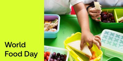 A child's arm reaching for a sandwich in a green container. A green strip covers the left side, with black text that reads 