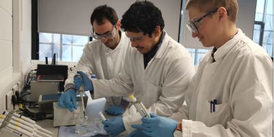A photograph of three students in a lab. (Lubsat).