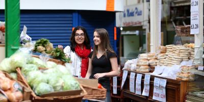 Two people at a produce stall in Leeds Kirkgate Markets.