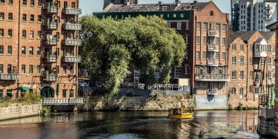 A yellow water taxi going down the river at calls landing in Leeds