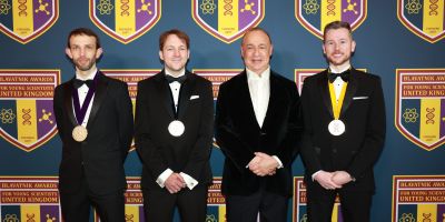 The Blavatnik UK Laureates and Sir Leonard Blavatnik in black-tie. The Laureates all have medals. Behind them is the Blavatnik Foundation emblem.