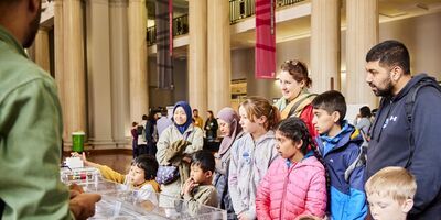 A group of families at a Be Curious stall.