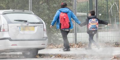 Children walking to school on a polluted road