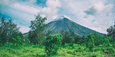 A volcano surrounded by green trees