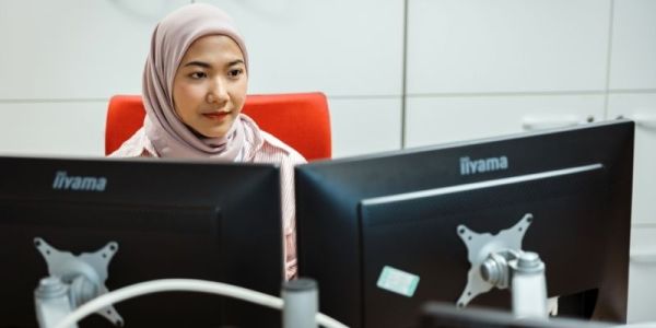 Image of ITS student working on two screens in the computer cluster.