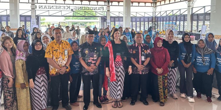 A large group of people stood together, facing the camera and smiling.