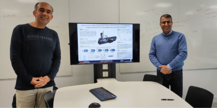 Image of ITS Masters student Mostafa Kazemi posing by a presentation with a colleague at the University of Leeds Institute of Transport department