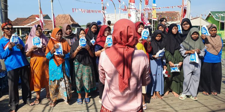 A group of women holding bags with menstrual products. Someone faces away from the camera towards them.