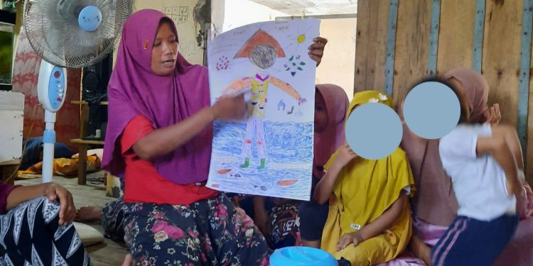 Someone holds and points to a hand-drawn "body map" that explores her experiences as a fisherwoman