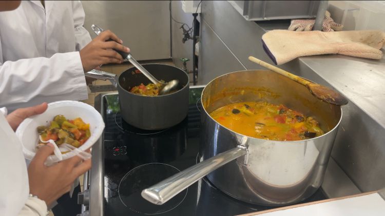 Two pans on a stovetop that contain vegetable curry