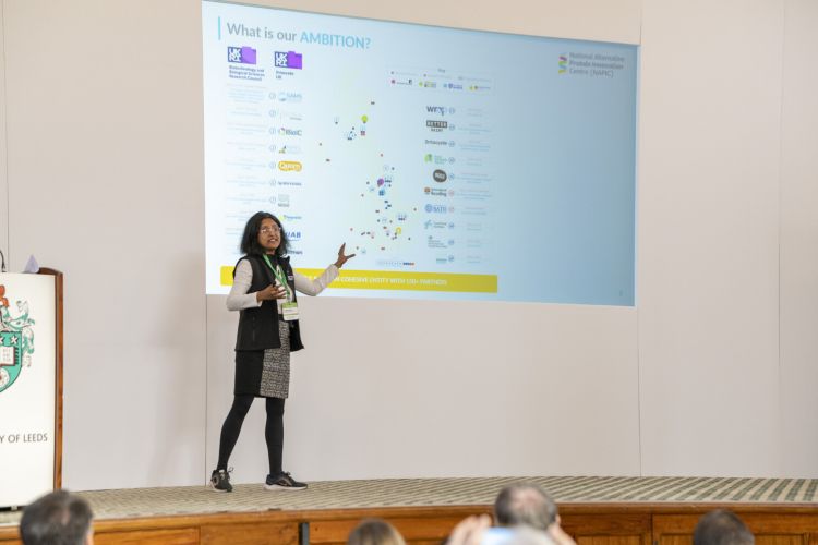 Professor anwesha sarkar presenting on stage at the napic launch event