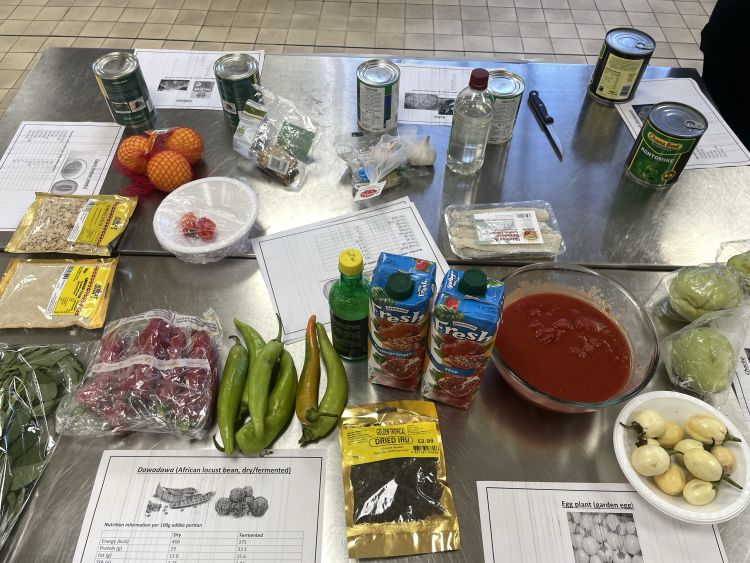 A table covered in African and Caribbean ingredients including chillis, melon seeds, dried saltfish, dried iru