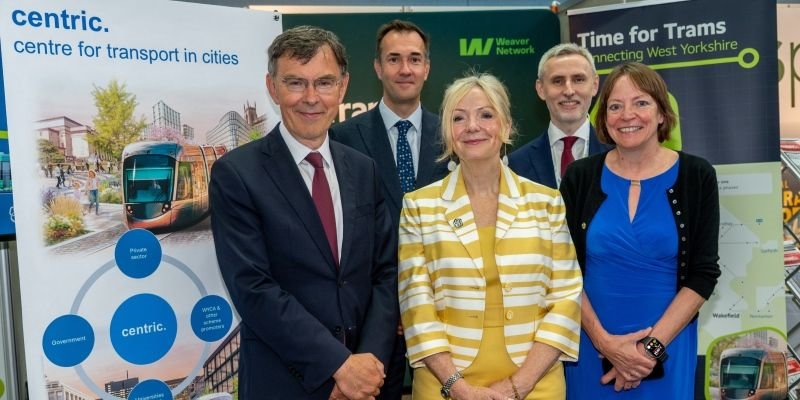 Representatives of the universities of leeds and huddersfield alongside mayor tracy brabin at a conference stand