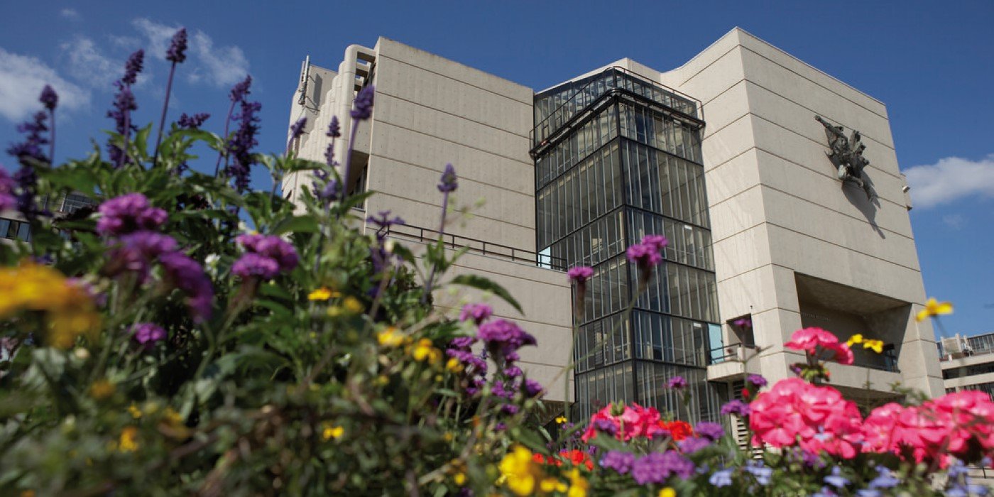 A ground view of the Roger Stevens building surrounded by flowers
